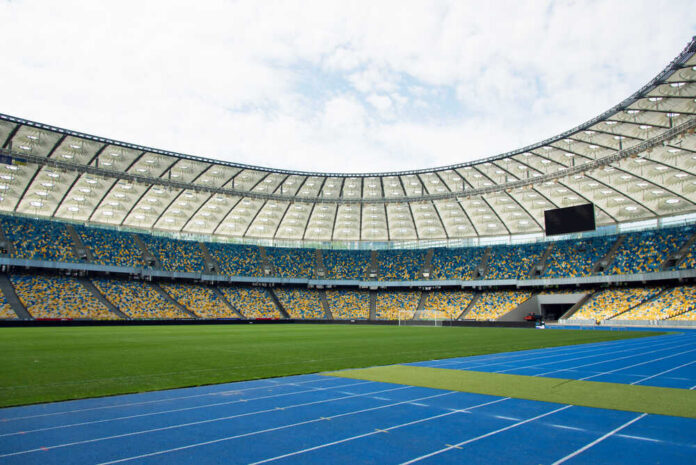 Empty stadium with blue running track and green field