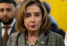 Nancy Pelosi wearing plaid blazer at event.