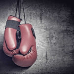 Road Rage Reversal Kills Rising Boxer Red boxing gloves on a dark, textured surface.