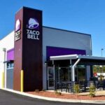 Diarrhea Parasite Targets Taco Bell? Exterior view of a Taco Bell restaurant with outdoor seating area