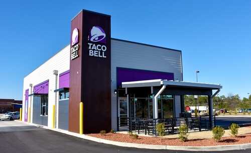 Exterior,Of,Taco,Bell,Fast-food,Restaurant,,Fayetteville,,North,Carolina,,Usa, Exterior view of a Taco Bell restaurant with outdoor seating area