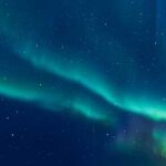 Cosmic Sugar Stuns Astronomers A vibrant display of the northern lights in a starry night sky