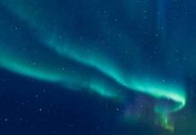 Cosmic Sugar Stuns Astronomers A vibrant display of the northern lights in a starry night sky