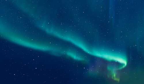 Northern,Lights,Or,Aurora,Borealis,In,The,Sky,-,Tromso, A vibrant display of the northern lights in a starry night sky