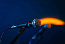 Fans Stunned: Music Superstar’s Disappearance Explained Close-up of a microphone on a stand, dark background.