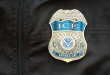 Airport Checkpoints Turn Into ICE Traps Close-up of an ICE officer badge on a black jacket