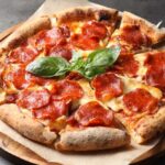 Pizza Icon Shrinks Fast — What Went Wrong? Pepperoni pizza with basil on a wooden board