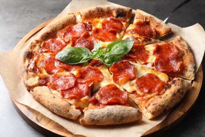 Tasty,Pepperoni,Pizza,With,Basil,On,Grey,Table Pepperoni pizza with basil on a wooden board