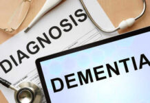 Medical diagnosis paperwork and a tablet displaying the word Dementia