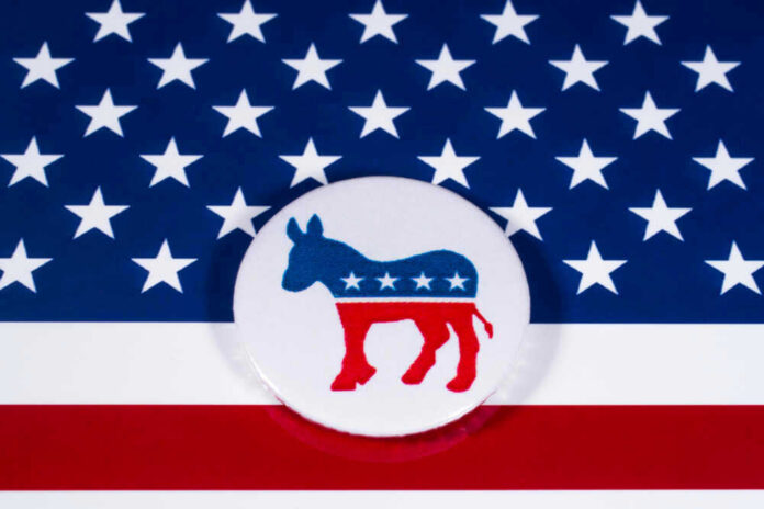 shutterstock_7864500311 Democratic Party donkey logo on American flag background.