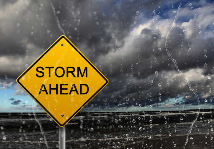 Yellow,Warning,Sign,Of,Bad,Weather,Ahead,Against,Stormy,Sky Aerial view of a swirling hurricane over the ocean