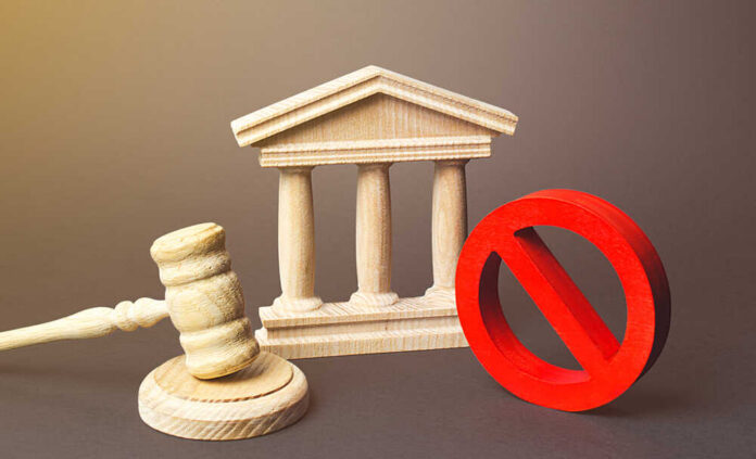 Wooden courthouse with a gavel and red prohibition symbol
