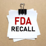 Walmart Soup Triggers 29-State Scare A notice labeled 'FDA RECALL' clipped to white papers on a brown background
