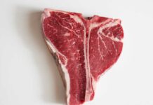 Raw T-bone steak on a white background