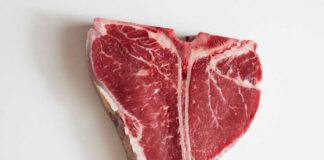 Raw T-bone steak on a white background