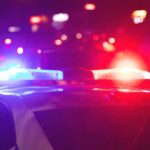 Shove Into Harbor — Prosecutors Pounce Police car with flashing red and blue lights at night