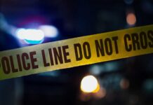 Police tape with blurred emergency lights in the background