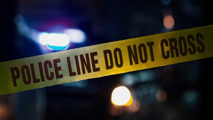 Police tape with blurred emergency lights in the background