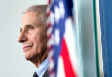 Inside Fauci’s January Jitters Anthony Fauci close-up with flag.