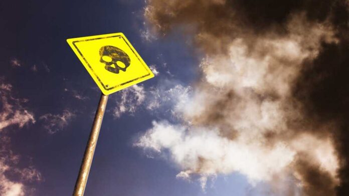 Road,Sign,Against,Blue,Sky.,Skull.,Danger,Of,Death.,3d Yellow warning sign with skull symbol under dramatic cloudy sky