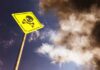 Lettuce Outbreak Turns Deadly Yellow skull and crossbones warning sign against smoky sky