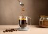 Caffeine Kids: Doctors Sound the Alarm Spoon sprinkling instant coffee granules into a glass cup