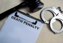 Clipboard with death penalty document beside gavel and handcuffs