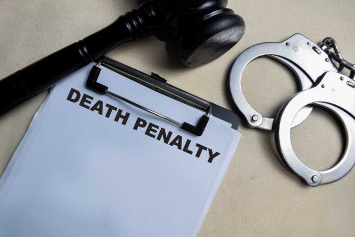 Concept,Of,Death,Penalty,Write,On,Clipboard,Isolated,On,Wooden Clipboard with death penalty document beside gavel and handcuffs
