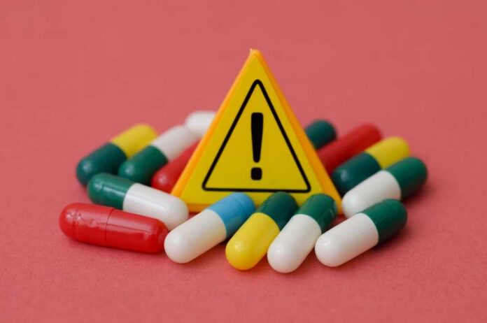 Yellow,Warning,Exclamation,Sign,Surrounded,By,Medical,Capsules,-,Drug