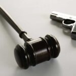 Judge Guts 1930s Gun Rules wooden judge's gavel with a handgun in the background