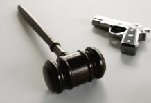 Judge Guts 1930s Gun Rules wooden judge's gavel with a handgun in the background
