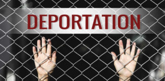 Hands reaching through a chain-link fence with the word 'DEPORTATION' above