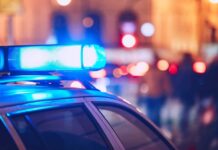 Second Death Inside THIS ICE Jail Close-up of a police car with blue emergency lights in a city at night