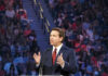 Ron DeSantis speaking at a podium before a large audience