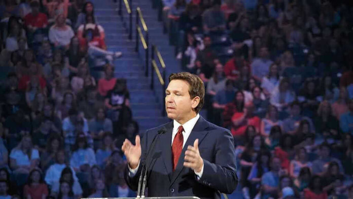 2291789741 Ron DeSantis speaking at a podium before a large audience