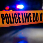 Another School Horror: Teacher Gunned Down Police tape with flashing lights in the background.
