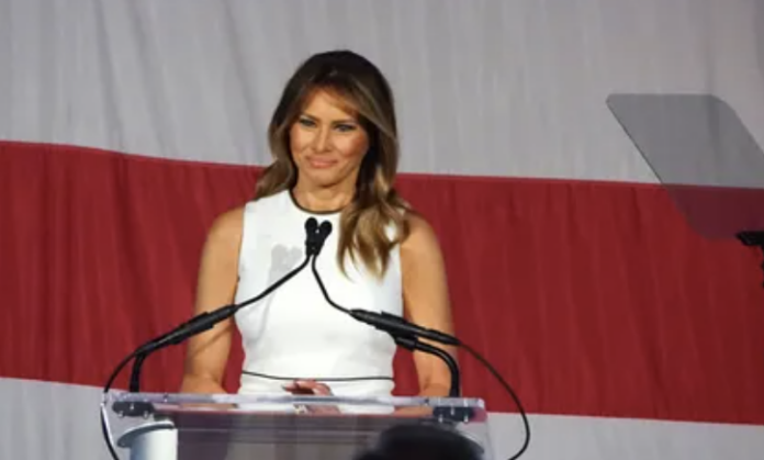 Melania-Trump Melania Trump speaking at a podium with microphones