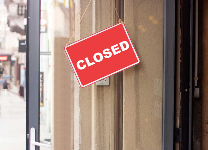 Business,Sign,That,Says,Closed,On,The,Glass,Door.,City A red 'CLOSED' sign hanging on a storefront door