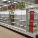 Empty supermarket shelves with great prices signage