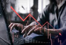 VIDEO: Worst Since 2014 – Brace For Pain Person typing on a laptop with a declining stock market graph overlay