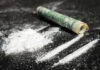 Cocaine lines with rolled banknote on surface