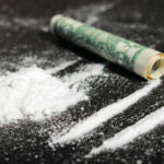 Cocaine lines with rolled banknote on surface