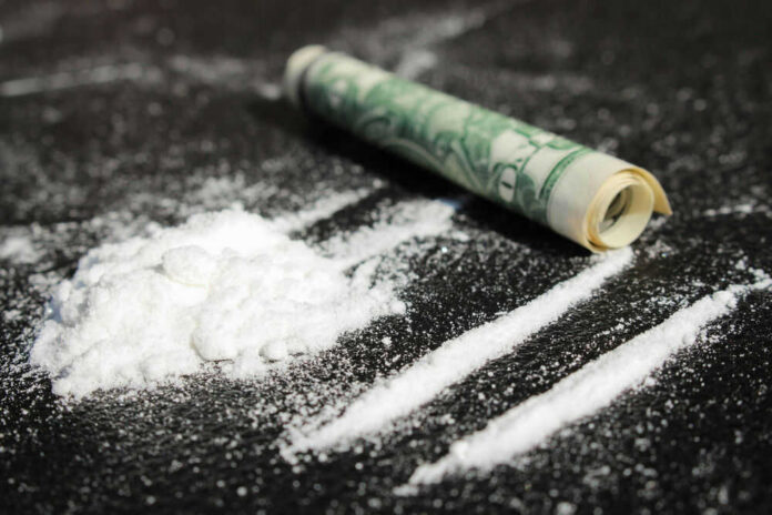 shutterstock_217852807 Cocaine lines with rolled banknote on surface
