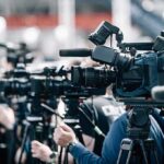 BREAKING: Acting Icon Gone — Hollywood Stunned Broadcast cameras on tripods at a press event