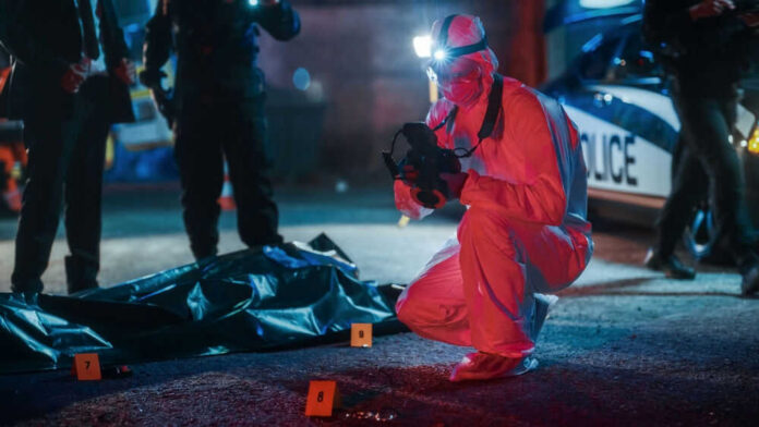 shutterstock_2230645973 Forensic investigator examines crime scene at night.
