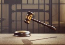 Judge Drops Bombshell Order on Prisons judge's gavel hovering above sound block in front of jail bars