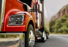 Close-up of a red truck on a road with a mountainous background