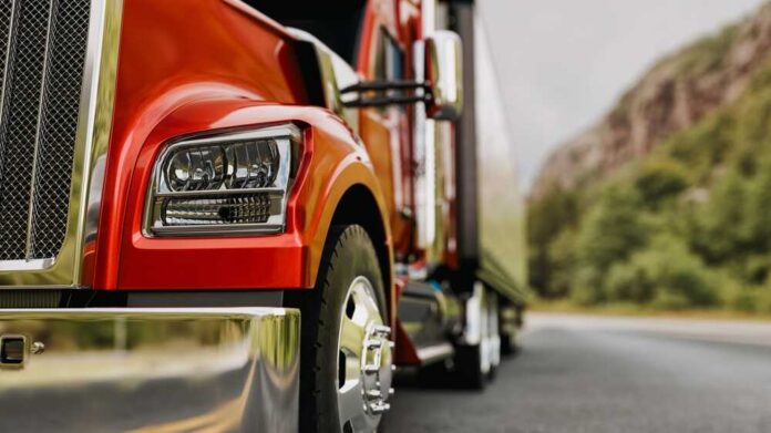 The,Truck,Runs,On,The,Highway,With,Speed.,3d,Rendering Close-up of a red truck on a road with a mountainous background