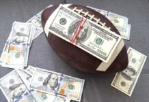 Fraud Bombshell Snags NFL Star Football with a stack of U.S. hundred-dollar bills secured by rubber bands