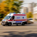 Ambulance van with flashing lights speeding through a city street
